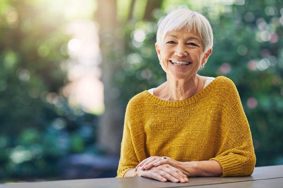 mature woman smiles outside