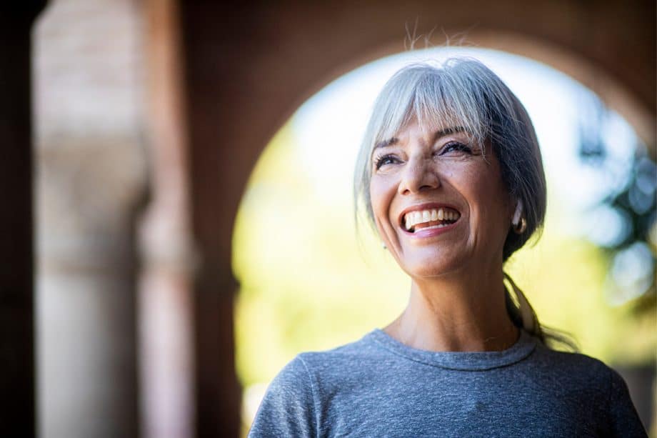 gray haired woman smiles outside