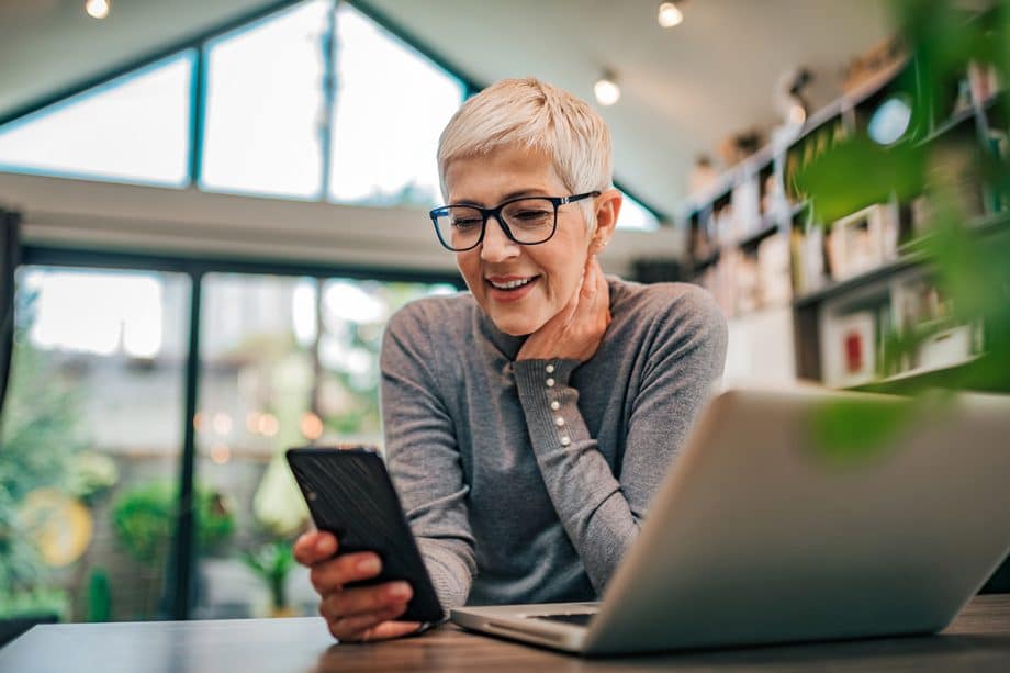 mature woman smiling while looking at her phone